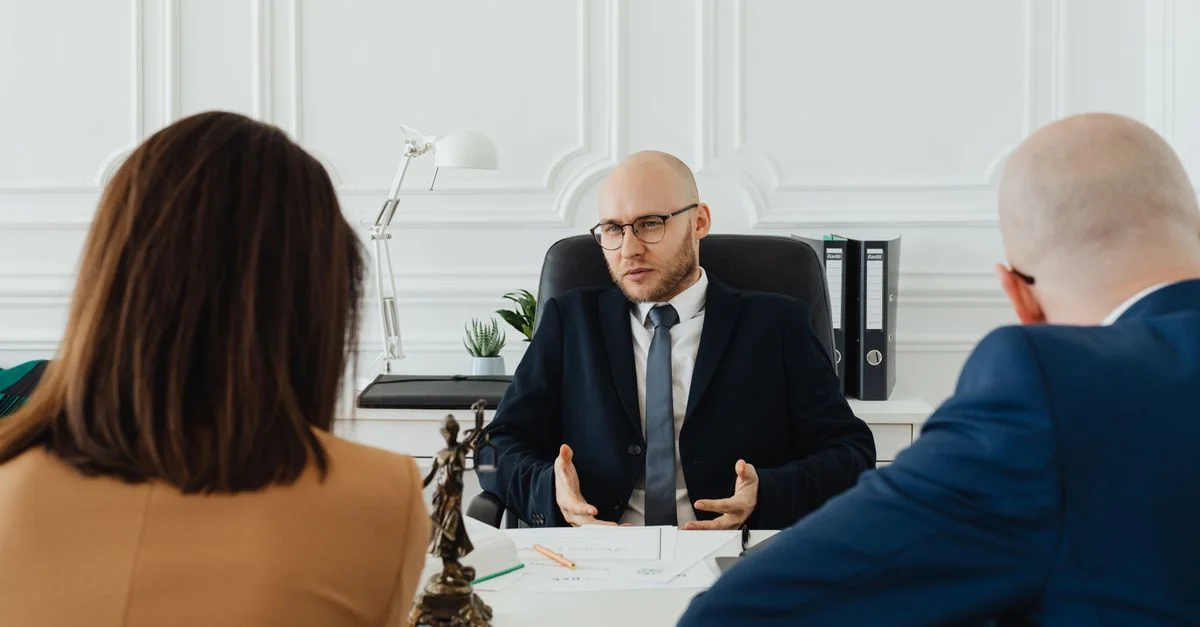 Una reunión de negocios profesional con un abogado y clientes en un entorno de oficina moderno.