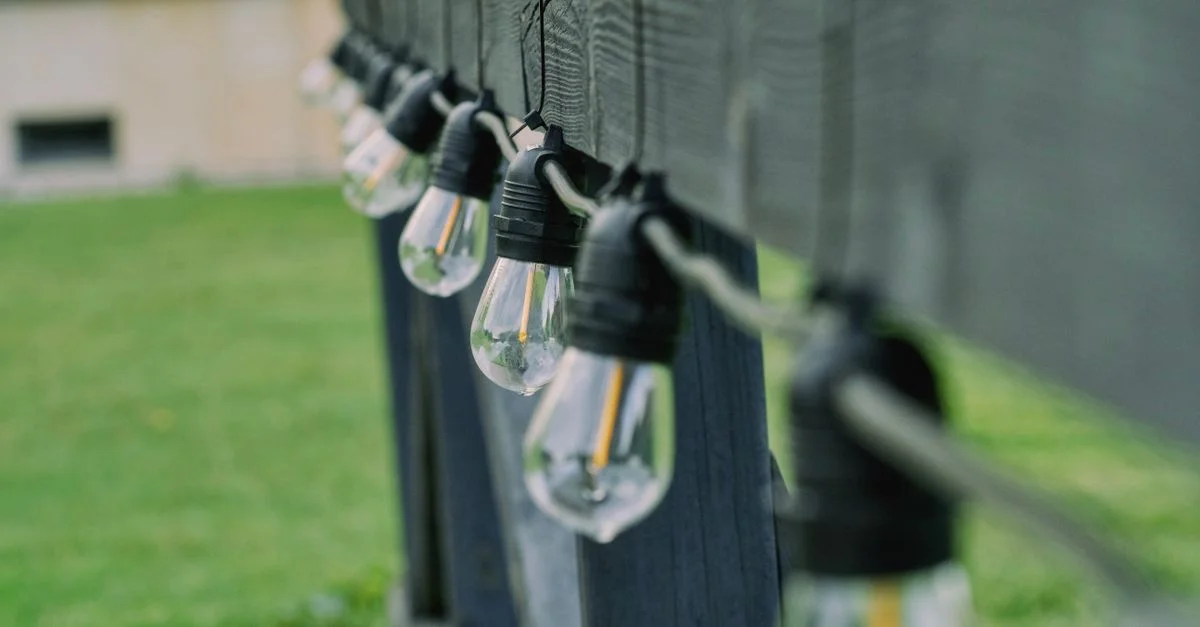 Guirlande d'ampoules LED suspendue à une barre de bois à l'extérieur, à Choroszcz, en Pologne.