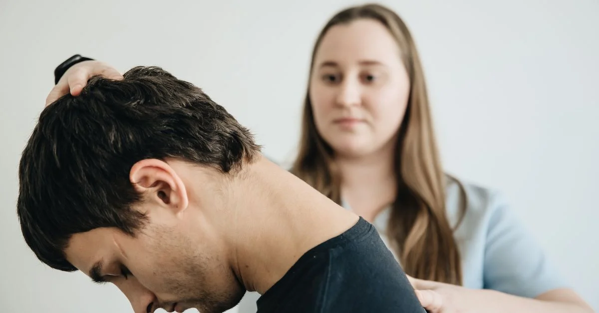 Un kinésithérapeute aide un patient avec des exercices de cou dans un cadre clinique.