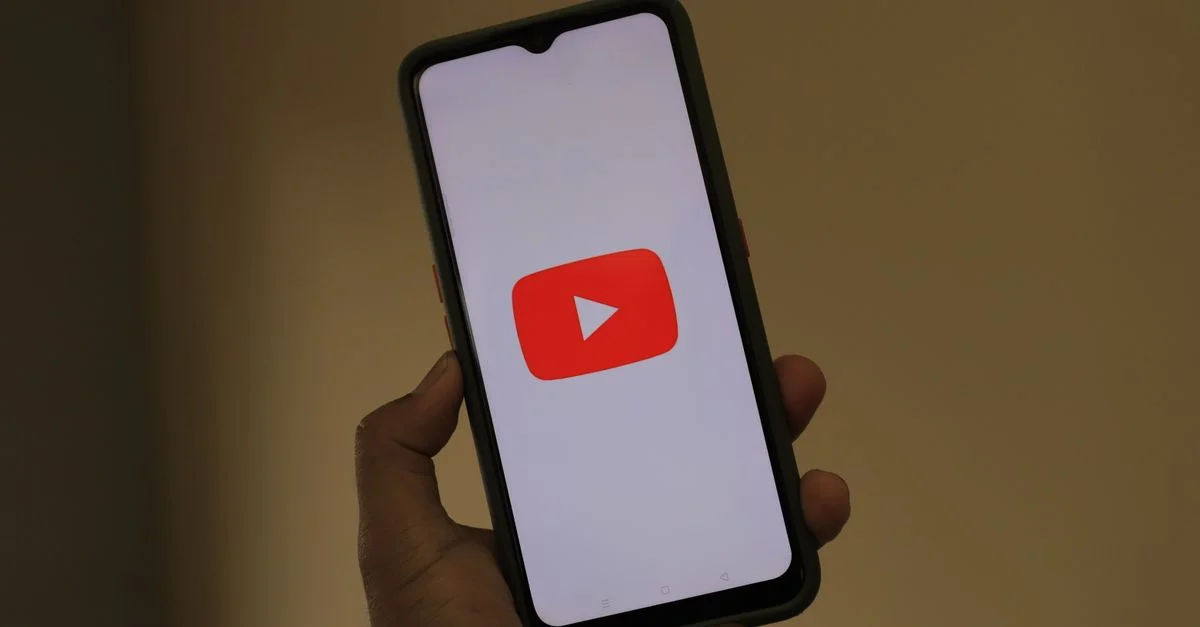Primer plano de un smartphone mostrando el logo de la aplicación de YouTube en la pantalla.