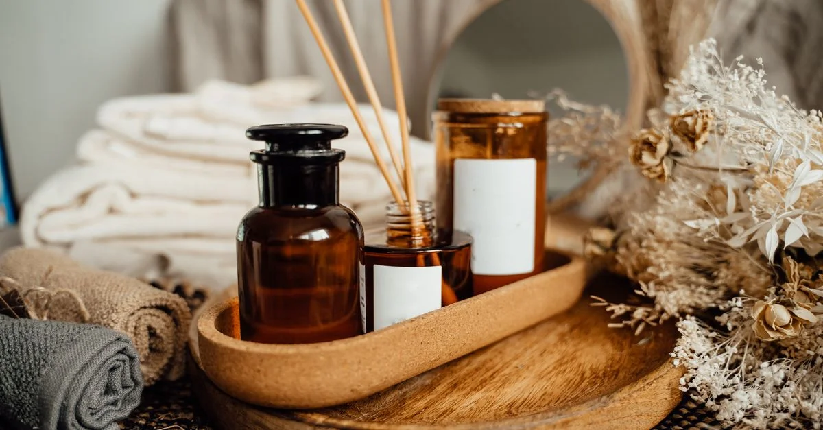 Un entorno de spa tranquilo con aceites de aromaterapia, velas y flores secas para la relajación.